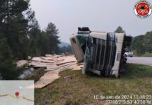 Carreta tomba e espalha carga de aglomerado pela pista