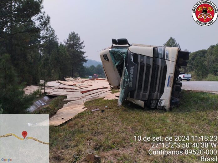 Carreta tomba e espalha carga de aglomerado pela pista