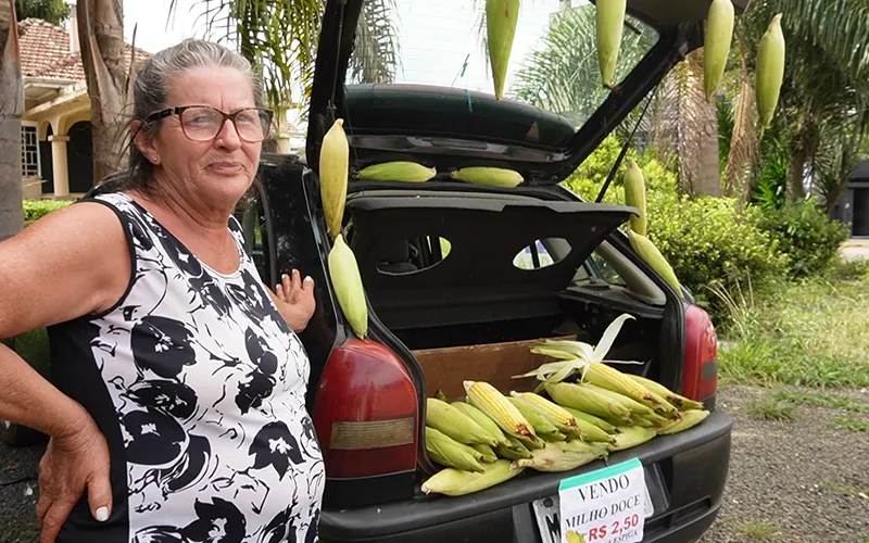 Lindamara vende milho verde junto ao carro da familia