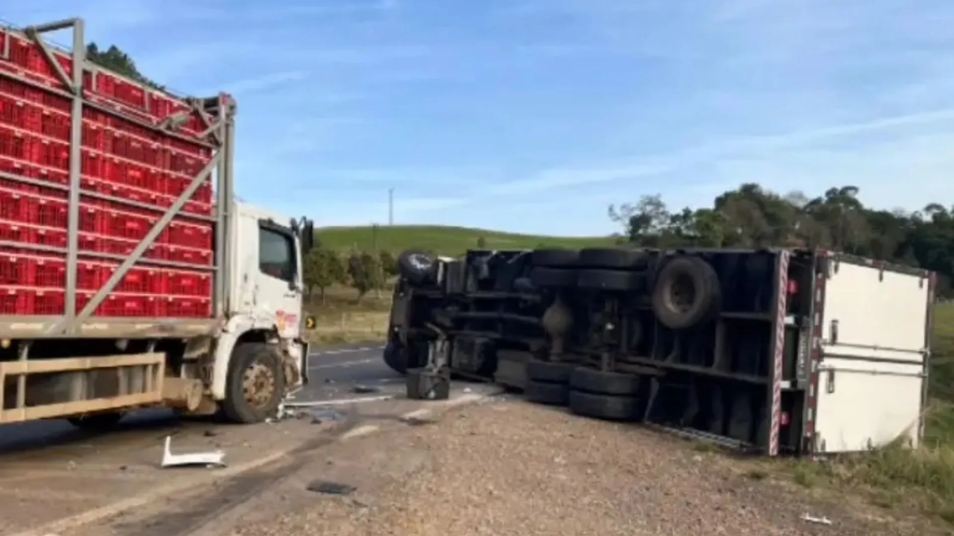 Caminhão tomba após colidir com caminhão de transporte de galinhas