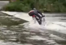 Motociclista tem moto arrastada por correnteza ao tentar atravessar ponte submersa