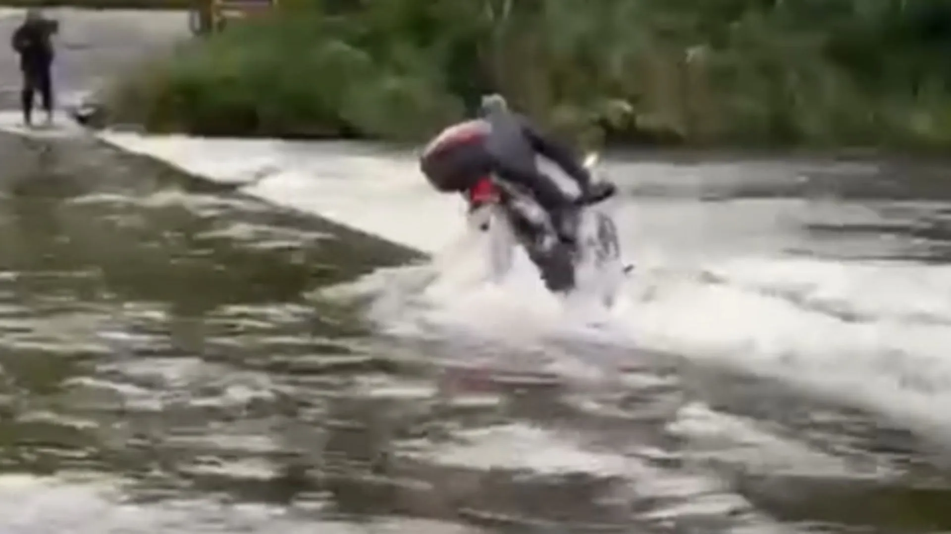 Motociclista tem moto arrastada por correnteza ao tentar atravessar ponte submersa