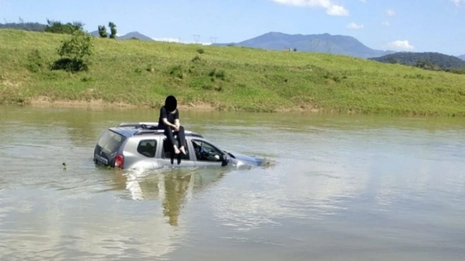 Jovem senta no teto do carro após cair em rio de SC