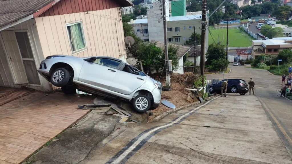 Carro desgovernado desce rua, bate em veículo e quase invade casa
